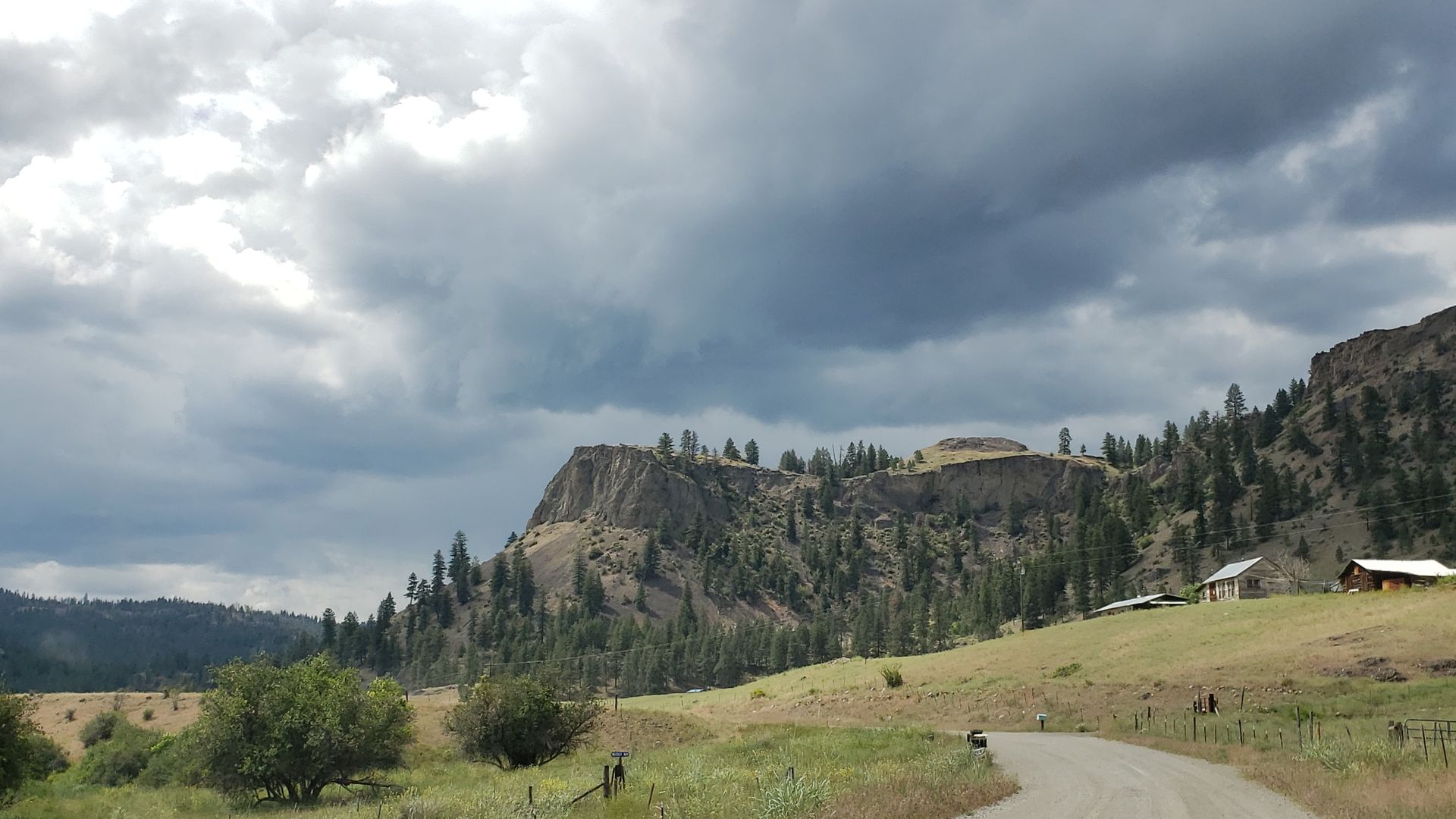 Storm clouds building over rock bluff in the Okanogan Highlands near Aeneas Valley