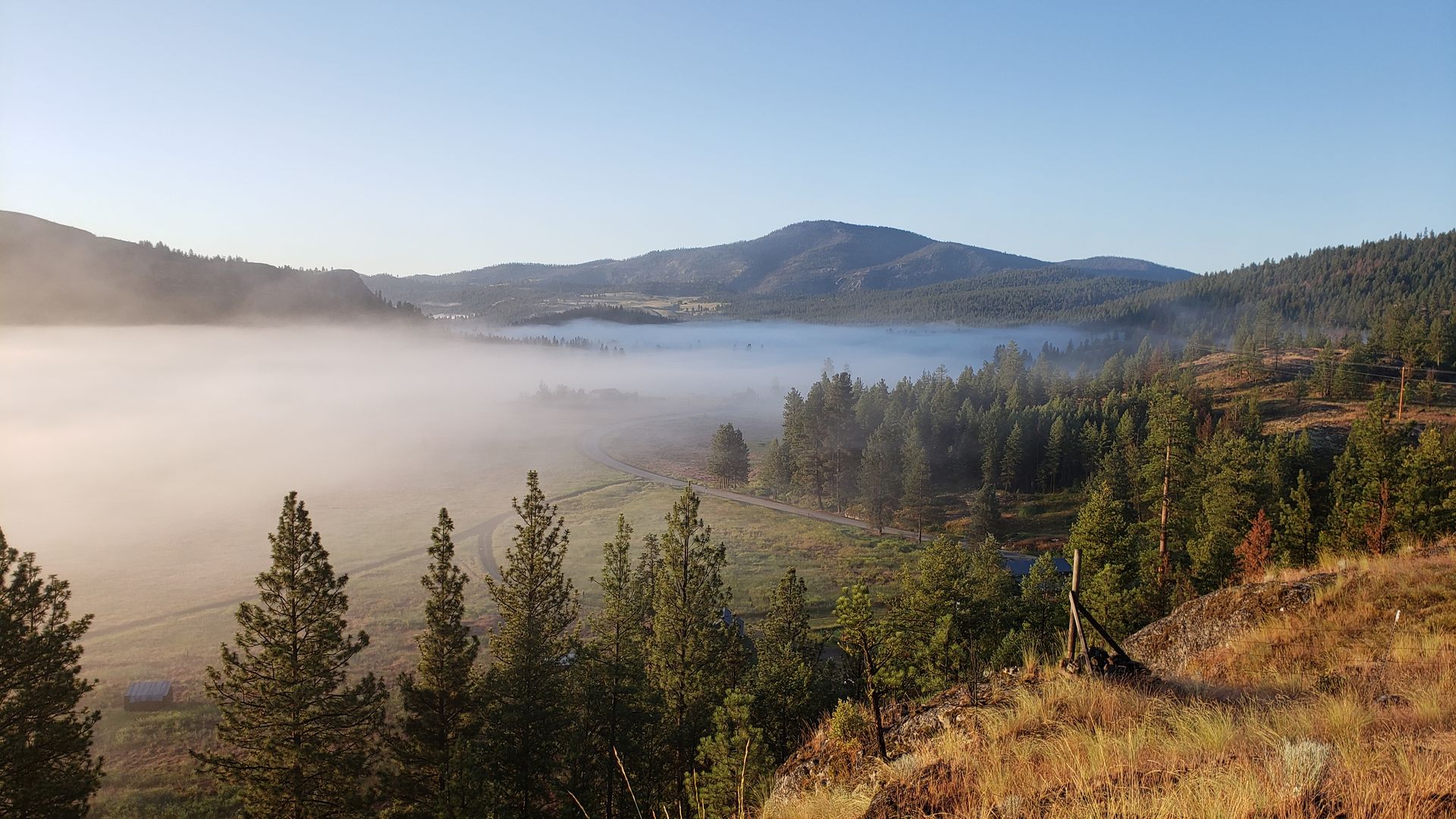 Fog clearing over Aeneas Valley on a morning, showing the valley corridor connecting to Tonasket